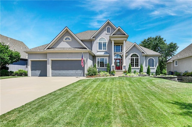 12333 Westgate St, Overland Park, KS 66213 - view of front of property with stucco siding, a front lawn, driveway, and an attached garage