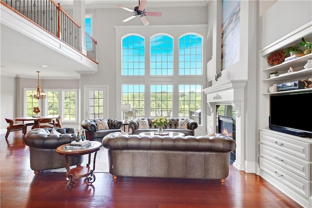 12333 Westgate St, Overland Park, KS 66213 - living room featuring a towering ceiling, ornamental molding, a glass covered fireplace, dark wood-type flooring, and a ceiling fan