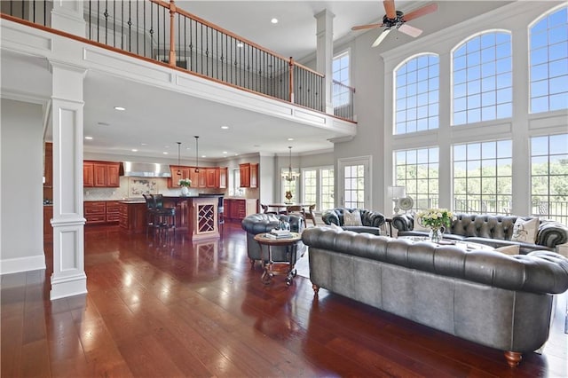 12333 Westgate St, Overland Park, KS 66213 - living area featuring ornate columns, a high ceiling, dark wood-style floors, a ceiling fan, and recessed lighting