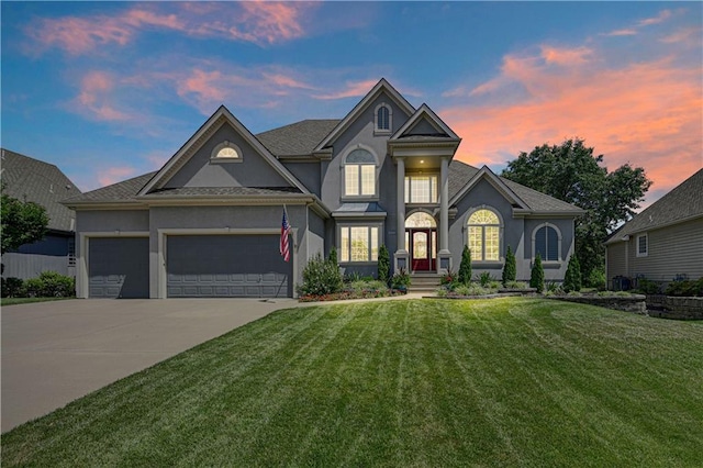 12333 Westgate St, Overland Park, KS 66213 - view of front of home featuring stucco siding, a yard, an attached garage, and concrete driveway