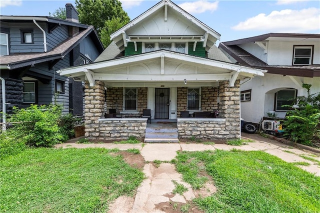 3443 Agnes Ave, Kansas City, MO 64128 - view of front of property featuring stone siding, a porch, roof with shingles, and stucco siding