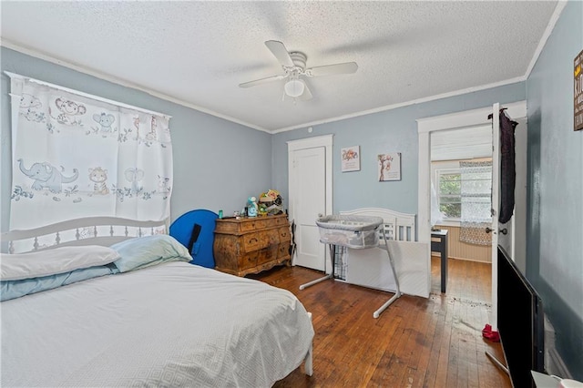 3443 Agnes Ave, Kansas City, MO 64128 - bedroom with hardwood / wood-style floors, ornamental molding, a textured ceiling, and a ceiling fan