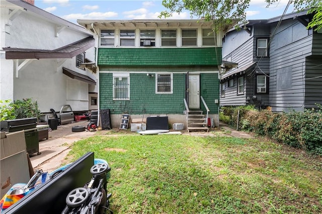 3443 Agnes Ave, Kansas City, MO 64128 - back of house featuring entry steps and a lawn