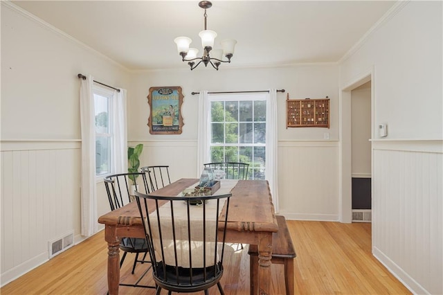 2010 Eugene Field Ave, Saint Joseph, MO 64505 - dining room featuring light wood-style flooring, a chandelier, wainscoting, and ornamental molding