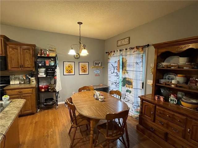 17540 W 159th Ct, Olathe, KS 66062 - dining space featuring light wood-style floors, a chandelier, and a textured ceiling