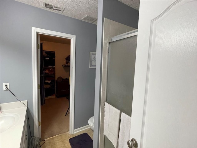 17540 W 159th Ct, Olathe, KS 66062 - full bath with a stall shower, a spacious closet, a textured ceiling, vanity, and tile patterned floors