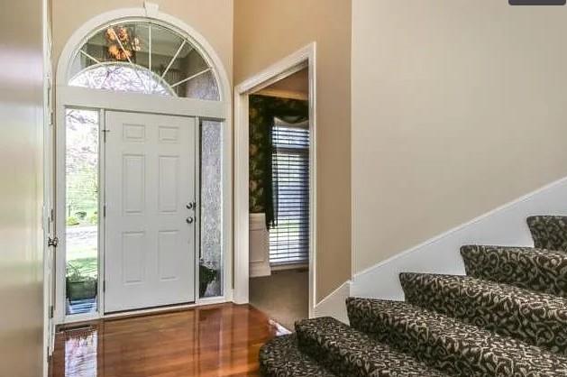 14301 Beverly St, Overland Park, KS 66223 - foyer featuring wood finished floors and stairs