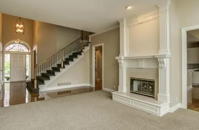14301 Beverly St, Overland Park, KS 66223 - unfurnished living room featuring carpet flooring, stairs, a chandelier, and a glass covered fireplace