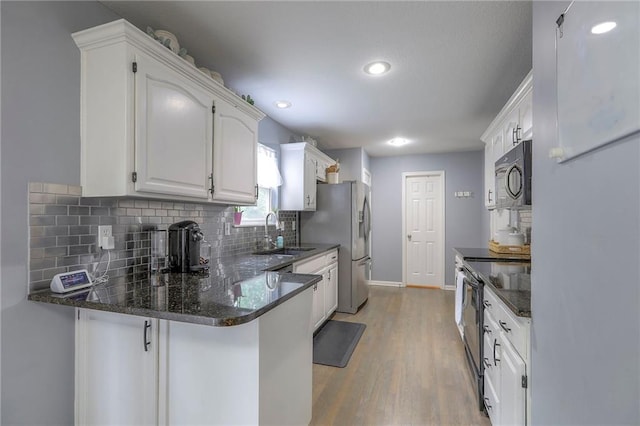 503 SW Creek Ridge Dr, Grain Valley, MO 64029 - kitchen featuring stainless steel refrigerator with ice dispenser, white cabinetry, decorative backsplash, light wood-style flooring, and a peninsula