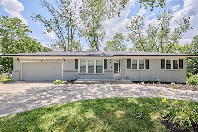7725 Cleveland Ave, Kansas City, KS 66109 - ranch-style home with an attached garage, board and batten siding, driveway, brick siding, and a shingled roof