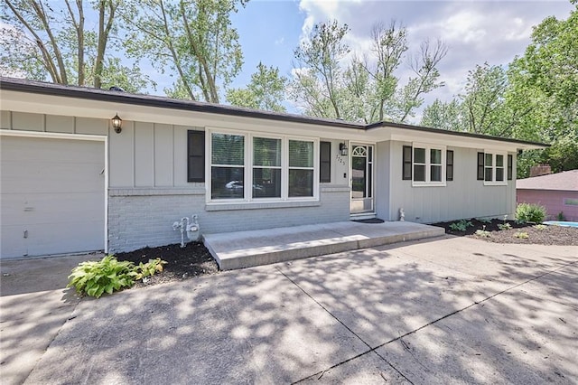 7725 Cleveland Ave, Kansas City, KS 66109 - ranch-style house with brick siding, board and batten siding, an attached garage, and driveway