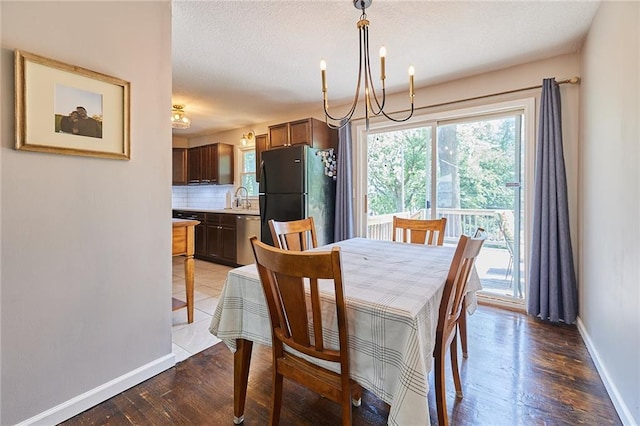 7725 Cleveland Ave, Kansas City, KS 66109 - dining area featuring healthy amount of natural light, wood finished floors, a chandelier, and a textured ceiling