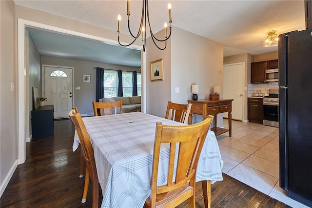 7725 Cleveland Ave, Kansas City, KS 66109 - dining area featuring light wood finished floors, a textured ceiling, and a chandelier
