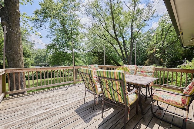 7725 Cleveland Ave, Kansas City, KS 66109 - wooden deck featuring outdoor dining space and view of wooded area