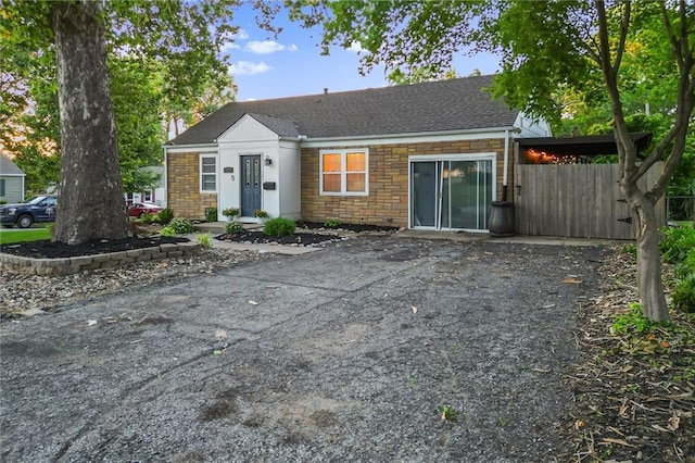 3600 NE 52nd Ter, Kansas City, MO 64119 - view of front of home with stone siding, a shingled roof, and a chimney
