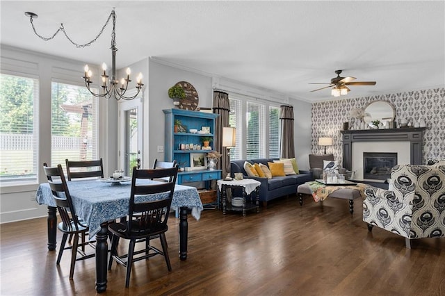 14920 S Roxburghe St, Olathe, KS 66061 - dining space featuring a chandelier, dark wood-style flooring, a ceiling fan, a glass covered fireplace, and crown molding