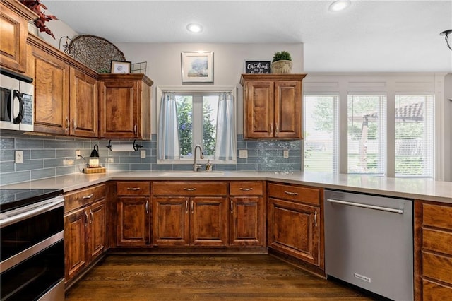 14920 S Roxburghe St, Olathe, KS 66061 - kitchen featuring appliances with stainless steel finishes, recessed lighting, tasteful backsplash, dark wood-type flooring, and light countertops