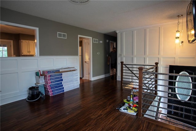 19707 E 14th St, Independence, MO 64056 - dining space featuring a decorative wall, dark wood-type flooring, and a textured ceiling