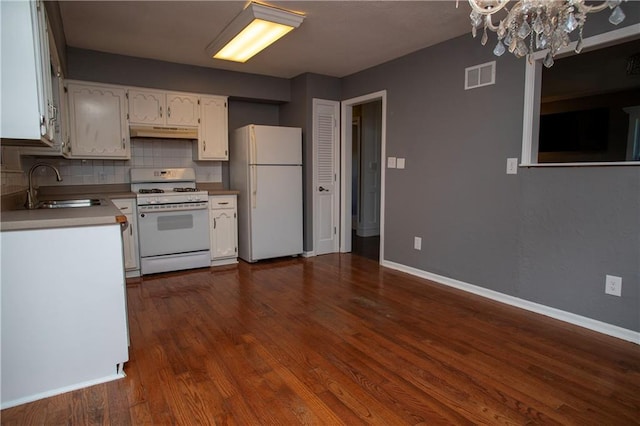 19707 E 14th St, Independence, MO 64056 - kitchen featuring white appliances, under cabinet range hood, a chandelier, white cabinetry, and backsplash