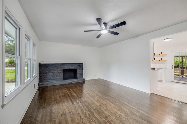 7909 Arnote Rd, Pleasant Valley, MO 64068 - unfurnished living room with wood finished floors, a fireplace, and ceiling fan