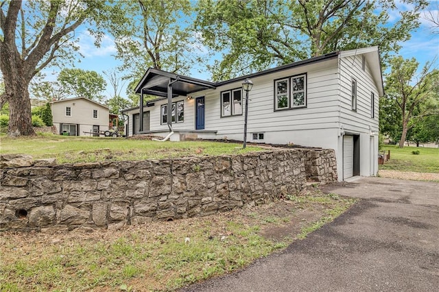 7909 Arnote Rd, Pleasant Valley, MO 64068 - view of front facade featuring a garage, driveway, and a front yard