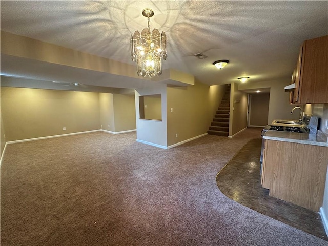 1103 SW Stonecreek Dr, Blue Springs, MO 64015 - kitchen featuring dark colored carpet, a textured ceiling, brown cabinetry, decorative light fixtures, and under cabinet range hood