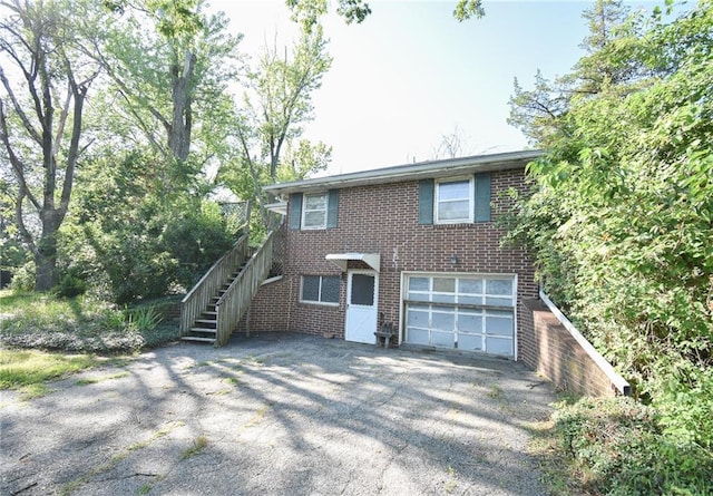 16210 Baxter Rd, Excelsior Springs, MO 64024 - view of front of home featuring stairway, brick siding, asphalt driveway, and an attached garage
