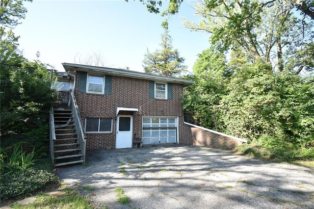 16210 Baxter Rd, Excelsior Springs, MO 64024 - view of front facade with stairway, brick siding, asphalt driveway, and a garage