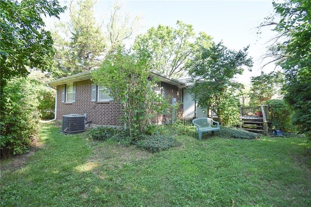 16210 Baxter Rd, Excelsior Springs, MO 64024 - view of side of property featuring brick siding, a lawn, and a wooden deck