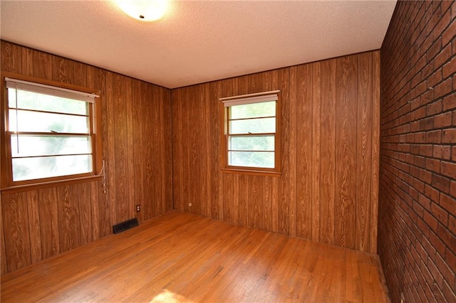 16210 Baxter Rd, Excelsior Springs, MO 64024 - unfurnished room with wood finished floors, wooden walls, and a textured ceiling