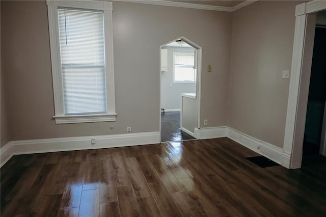 2603 Patee St, Saint Joseph, MO 64507 - spare room featuring crown molding, dark wood-style floors, and arched walkways