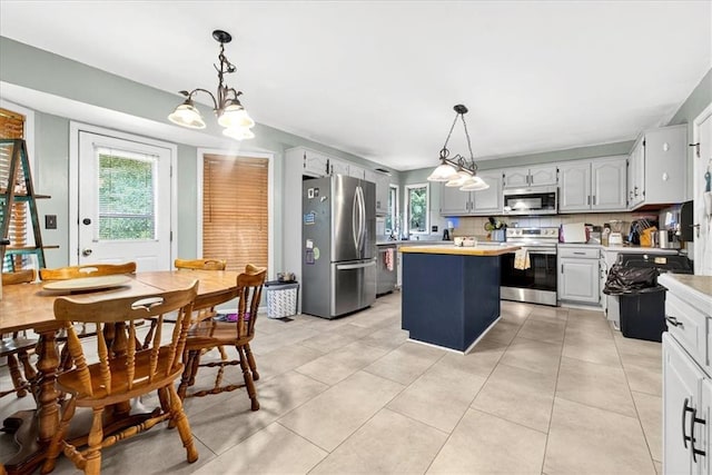 15820 W 150th Ter, Olathe, KS 66062 - kitchen featuring stainless steel appliances, light countertops, a center island, a chandelier, and light tile patterned floors