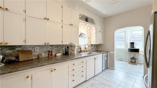 309 College St, Paola, KS 66071 - kitchen featuring appliances with stainless steel finishes, backsplash, and white cabinetry