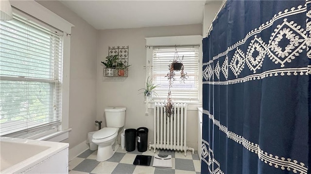309 College St, Paola, KS 66071 - full bathroom featuring radiator heating unit, tile patterned floors, plenty of natural light, and vanity