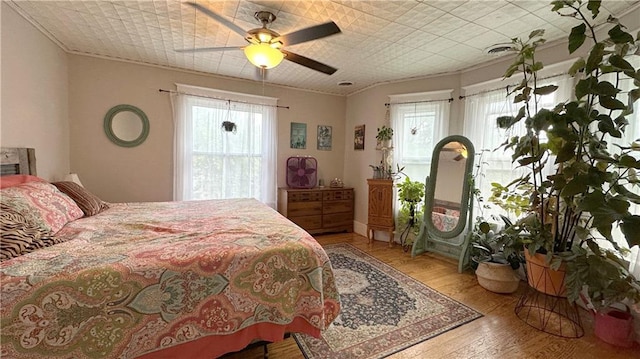 309 College St, Paola, KS 66071 - bedroom featuring multiple windows, ornamental molding, hardwood / wood-style flooring, and ceiling fan