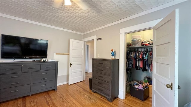 309 College St, Paola, KS 66071 - bedroom with light wood-type flooring, a closet, and crown molding