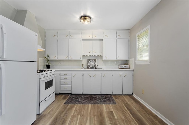 5921 Lexington Ave, Kansas City, MO 64123 - kitchen with white appliances, light countertops, decorative backsplash, and white cabinetry