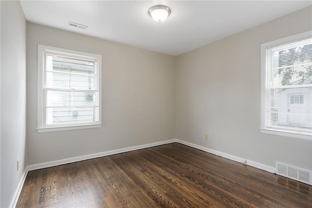 5921 Lexington Ave, Kansas City, MO 64123 - empty room featuring healthy amount of natural light and dark wood finished floors