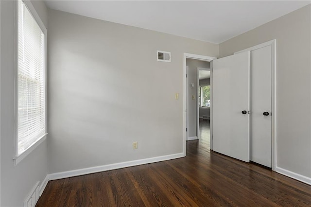 5921 Lexington Ave, Kansas City, MO 64123 - unfurnished bedroom with dark wood-style flooring and baseboards