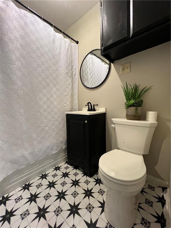 5921 Lexington Ave, Kansas City, MO 64123 - bathroom featuring vanity, tile patterned floors, and a shower with shower curtain