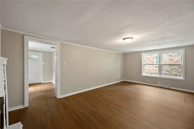 813 S Hardy Ave, Independence, MO 64053 - empty room featuring dark wood-style floors, a fireplace, and crown molding