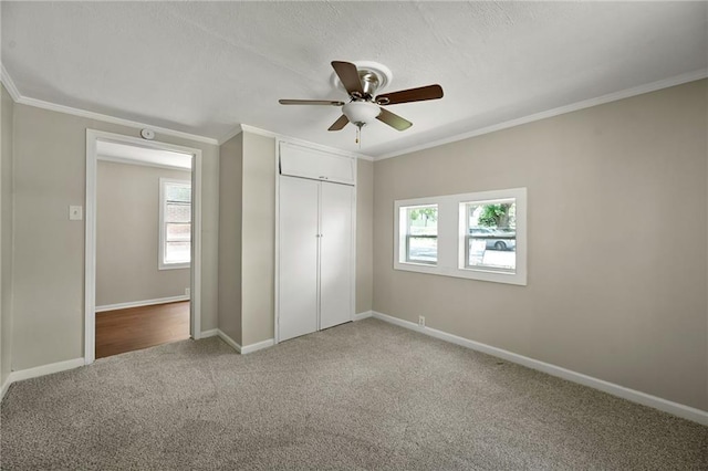 813 S Hardy Ave, Independence, MO 64053 - unfurnished bedroom featuring crown molding, multiple windows, carpet flooring, a closet, and a ceiling fan
