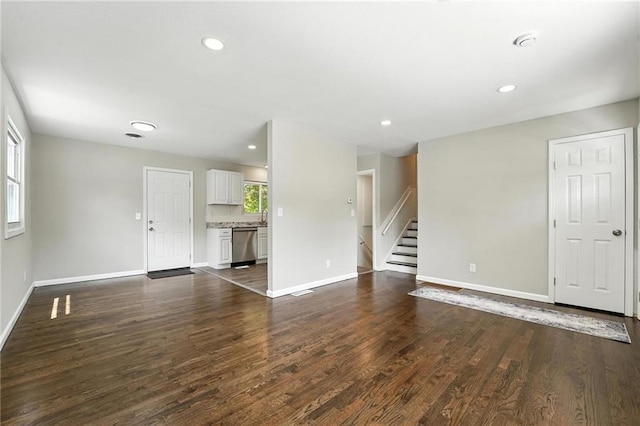 4916 N Manchester Ave, Kansas City, MO 64119 - unfurnished living room featuring dark wood-style flooring, stairs, and recessed lighting