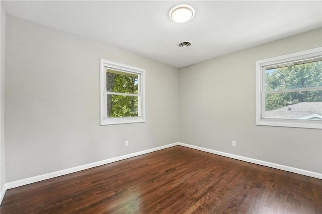4916 N Manchester Ave, Kansas City, MO 64119 - empty room with healthy amount of natural light and dark wood-type flooring