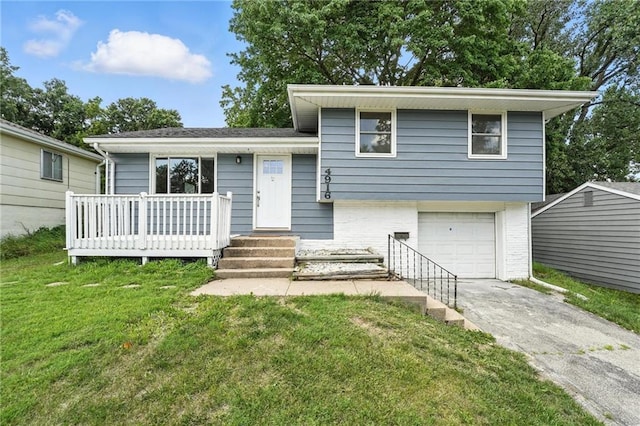 4916 N Manchester Ave, Kansas City, MO 64119 - split level home featuring a garage, driveway, a front lawn, and brick siding