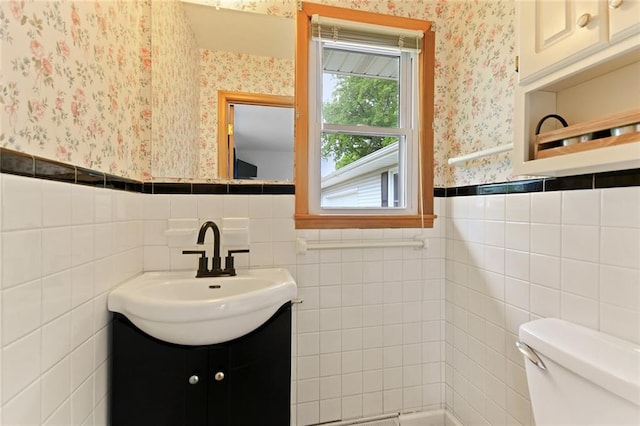 904 Leone Ave, Sedalia, MO 65301 - bathroom with wallpapered walls, a wainscoted wall, vanity, and tile walls