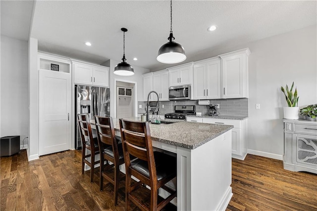 1296 NW Lindenwood Dr, Grain Valley, MO 64029 - kitchen featuring stainless steel appliances, dark wood finished floors, decorative backsplash, a kitchen breakfast bar, and recessed lighting