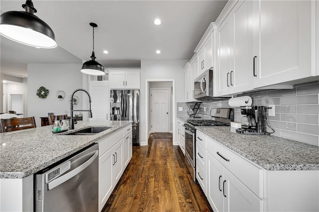 1296 NW Lindenwood Dr, Grain Valley, MO 64029 - kitchen with stainless steel appliances, dark wood-style floors, white cabinets, light stone counters, and recessed lighting