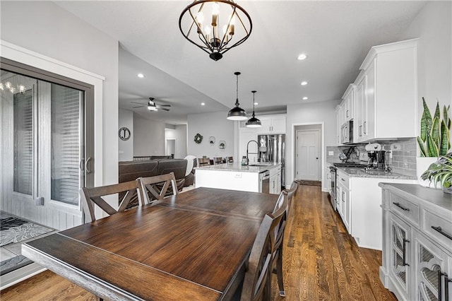 1296 NW Lindenwood Dr, Grain Valley, MO 64029 - dining area featuring dark wood-style floors, ceiling fan, a chandelier, and recessed lighting