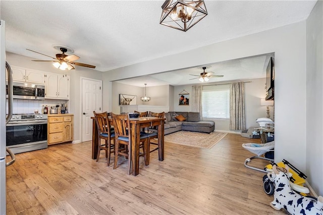 4252 SE Valleyview Ln, Holt, MO 64048 - dining space featuring ceiling fan, light wood-type flooring, a chandelier, and a textured ceiling